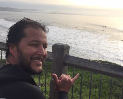 Eric Hinote, throwing shaka after surfing The Hook in Santa Cruz California